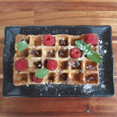 protein waffle with chocolate, raspberries and maple syrup